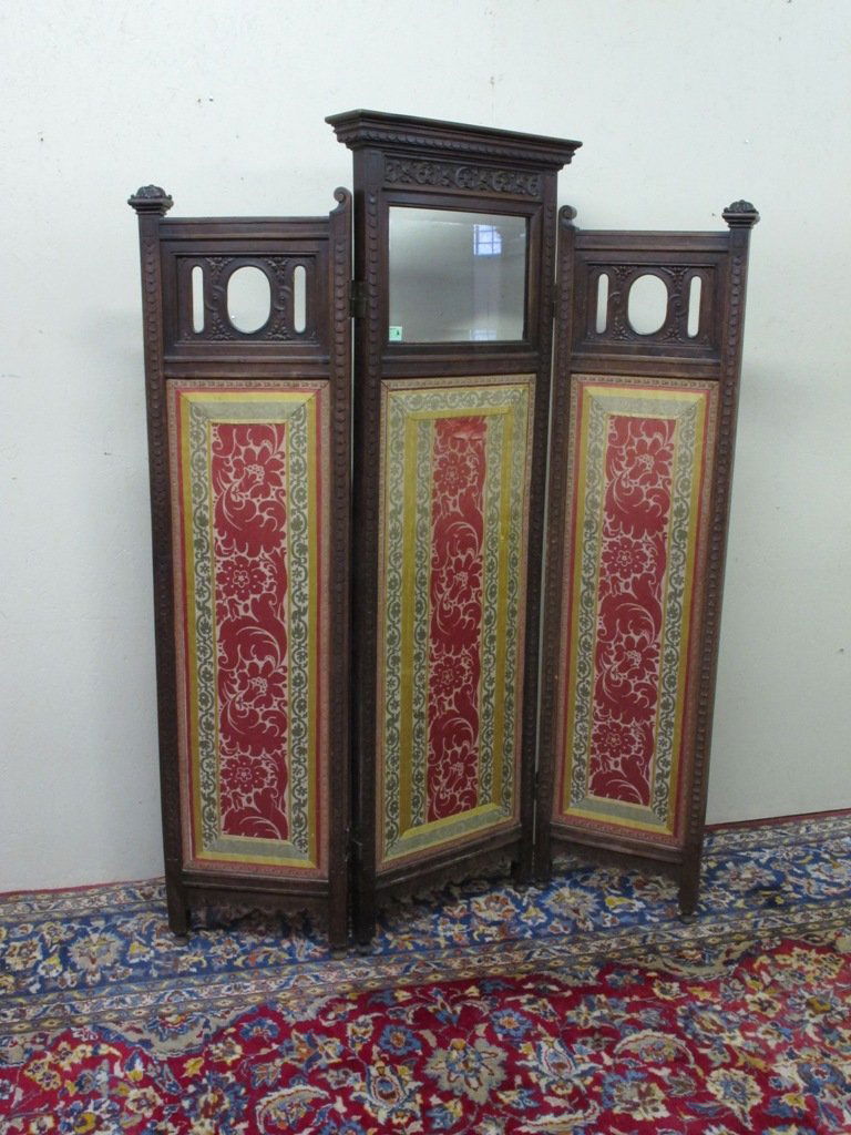 EDWARDIAN THREE PANEL SCREEN:: Edwardian Three Panel Screen, the center panel with graduated cornice above a beveled rectangular mirror over an embroidered silk panel, the side panels having scrolled finials above pierced, carved p