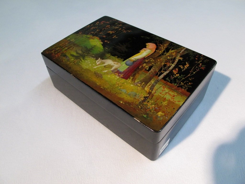 RUSSIAN FINELY PAINTED & SIGNED LAQUER BOX:: A Russian Black Lacquer Box, 20th century, depicting a young woman with lamb in a forest and inscribed Made in USSR on underside. Overall good stable condition with wear appropriate to age and use. Ap