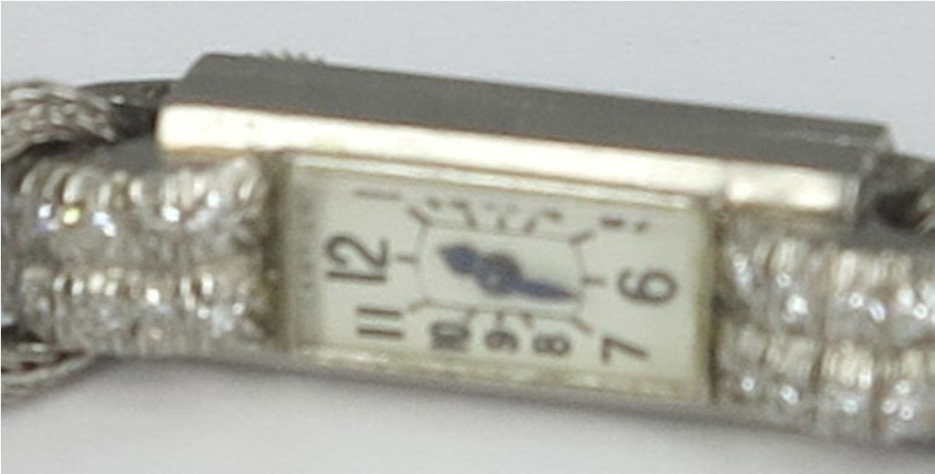 CARTIER LADY'S WRIST WATCH: Elongated rectangular form, strap ends set with ten small round mine cut diamonds. The face signed Cartier, France. Rear mounted thumb wind with later double mesh strand band.