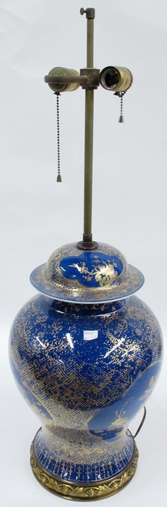 CHINESE PORCELAIN LAMP:: A Chinese Porcelain Lamp, 20th century, the lamp having two lighting elements and of baluster form with gold floral and foliate decoration on a celadon blue ground, raised on a brass decorative foot.