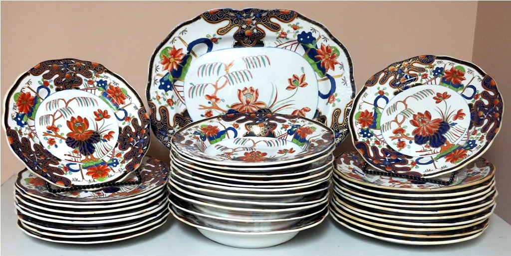 ENGLISH IMARI DINNER SERVICE: A 19th Century 32 piece English Masons Ironstone dinner service. Polychrome glazed in an Imari pattern in cobalt, burnt orange and green tones on a white ground with parcel gilt decoration. Comprised 