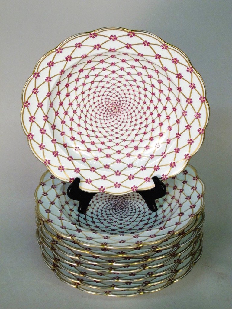LIMOGES PARTIAL PORCELAIN DINNER SERVICE:: A Limoges Partial Porcelain Dinner Service, comprising 8 dinner plates, molded, enameled and gilt with an interlaced spiral basketwork pattern of gilt lines, studded at intersections with five-petaled