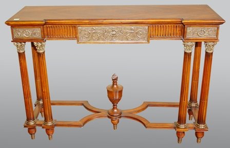 A NEOCLASSICAL STYLE FLAME MAHOGANY CONSOLE TABLE:: 20th century, having a rectangular top above one long and two short drawers raised on columns with brass Corinthian capitals joined by an X stretcher with center urn finial. Height 30 x width 51 1/2 x