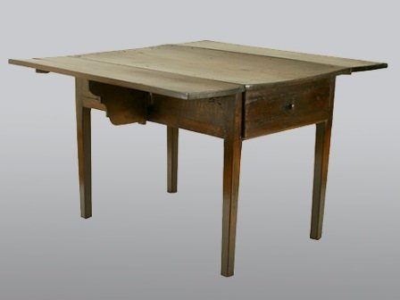 A SPANISH PROVINCIAL WALNUT DROP LEAF TABLE:: probably late 16th century, having two drop leaves with scalloped edged supports, the table with one long drawer, raised on tapered legs. Height 31 1/3 x width 28 x depth 46 1/2 inches. Old repairs no