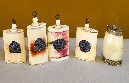 A GROUP OF ASIAN IVORY AND BONE SNUFF BOTTLES:: 1st quarter of the 20th century, comprising four bottles having orb finials with metal ring pulls and another example with metal top and chaised metal base. Height of tallest 2 3/4 inches.