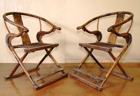 A PAIR OF CHINESE HORSESHOE BACK FOLDING CHAIRS:: having brass mounts with carved backsplats over the seats with woven rope above the rectangular footrests. Height 34 1/2 x width 29 x depth 16 inches.