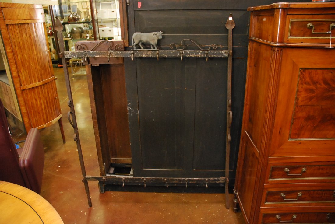 A CAST IRON BUTCHER'S RACK:: the rack having a cast iron figure of a bull above the square frame with numerous hooks. Height 55 x width 44 inches.