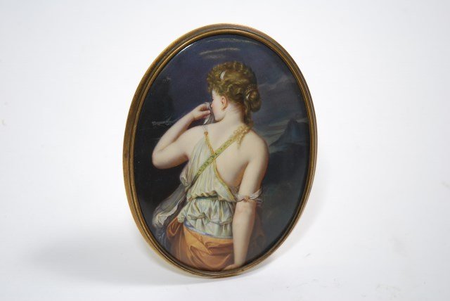 PAINTING ON PORCELAIN: The oval painting depicting the back of a young classically robed female standing in front of a mountainous landscape. Mounted in a gilt moulded metal frame. Incised marks to back and pencil lettering