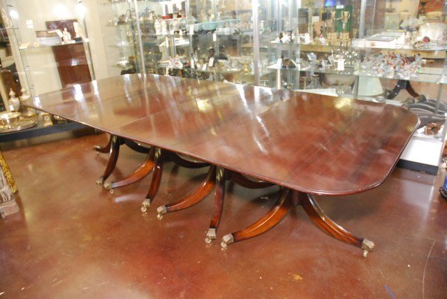 ANTIQUE MAHOGANY FOUR PEDESTAL DINING TABLE: 19th Century dining table on four pedestals. Turned bases with down swept feet ending in brass paw castered feet. Two end sections each 34"D X 52" W with two center sections each 25 1/4"W. Three leave
