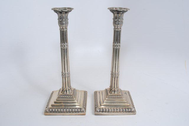 PAIR OF1759 STERLING REEDED COLUMN CANDLESTICKS: A pair of 1759 English candlesticks reeded column design with a flaring foliate candle cup on a stepped square base. London hallmark. Makers mark illegible possibly EC. Heavy type. Unable to weigh sil