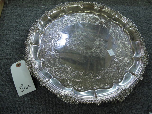 19TH CENTURY ENGLISH STERLING SALVER: Heavy sterling salver with Virtus crest showing a man holding an oar?. On four feet. Possibly by Phillip Rundell. Marked with a P.R, Sterling, London, 1818 date mark. Good condition. Approx. 58 Troy O