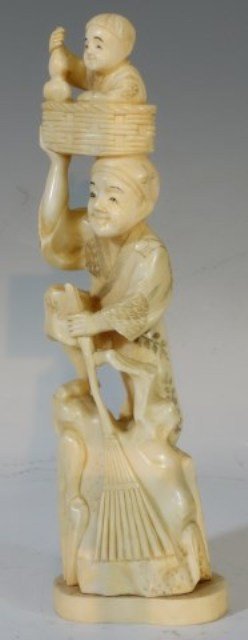 CARVED ASIAN IVORY FIGURE PEASANT AND BOY: Early 20th century. The carving depicts a male pheasant holding a plum branch standing on a rock with a boy at his feet. Character marks to base. 8 1/2"H