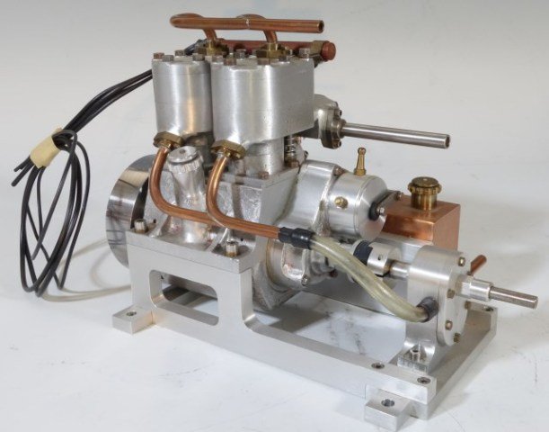 ALUMINUM TWO GAS CYLINDER ENGINE: Hand milled and constructed by Carl Roby to scale in aluminum with copper tank and tubing. Two cylinders with wired spark plugs. 5 3/4"H X 8 1/2"W X 4 3/4"D. Excellent condition.