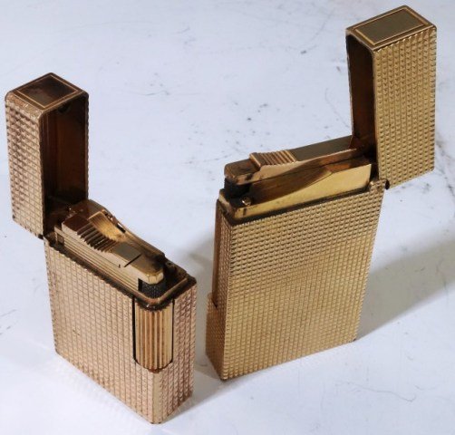 TWO S.T. DUPONT LIGHTERS: one large and one regular. Marked plaque G Small marked W9908 Paris Made in France 1 1/2"H Large Marked 0gbb98 about 2 1/2"H Both with French touch marks