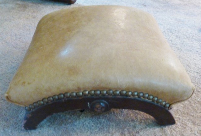 FOOTREST: A 19th Century American Victorian walnut arched footrest having a brass tacked tan leather upholstered top. Measures: 12½" L x 12½" W x 6½" H.