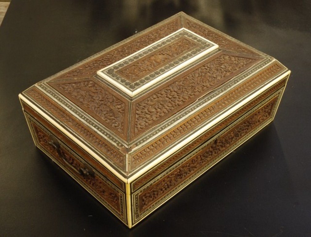 MIDDLE EASTERN CARVED AND FITTED BOX: Heavily carved with elephants and birds in a floral landscape ivory inlay. Opens to fitted interior. Losses to inlays and interior. 5 1/2"H X 14"W X 7 1/2"D