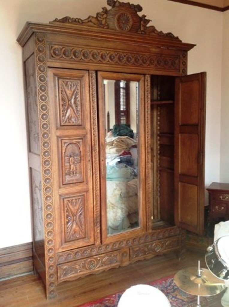 CONTINENTAL RENAISSANCE OAK ARMOIRE:: 19th century, the center with carved foliate crest above the graduated cornice over the carved frieze with floral medallions, the case with center beveled glass door bordered by two doors with three c