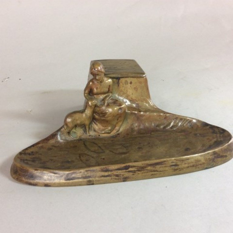 PAUL TERESZCZUK 1895-1925 BRONZE DESK TRAY: The figural desk tray cast on the form of a woman feeding a sheep. Golden brown ptina repaired glass insert. 3"H X 8"L X 6"D