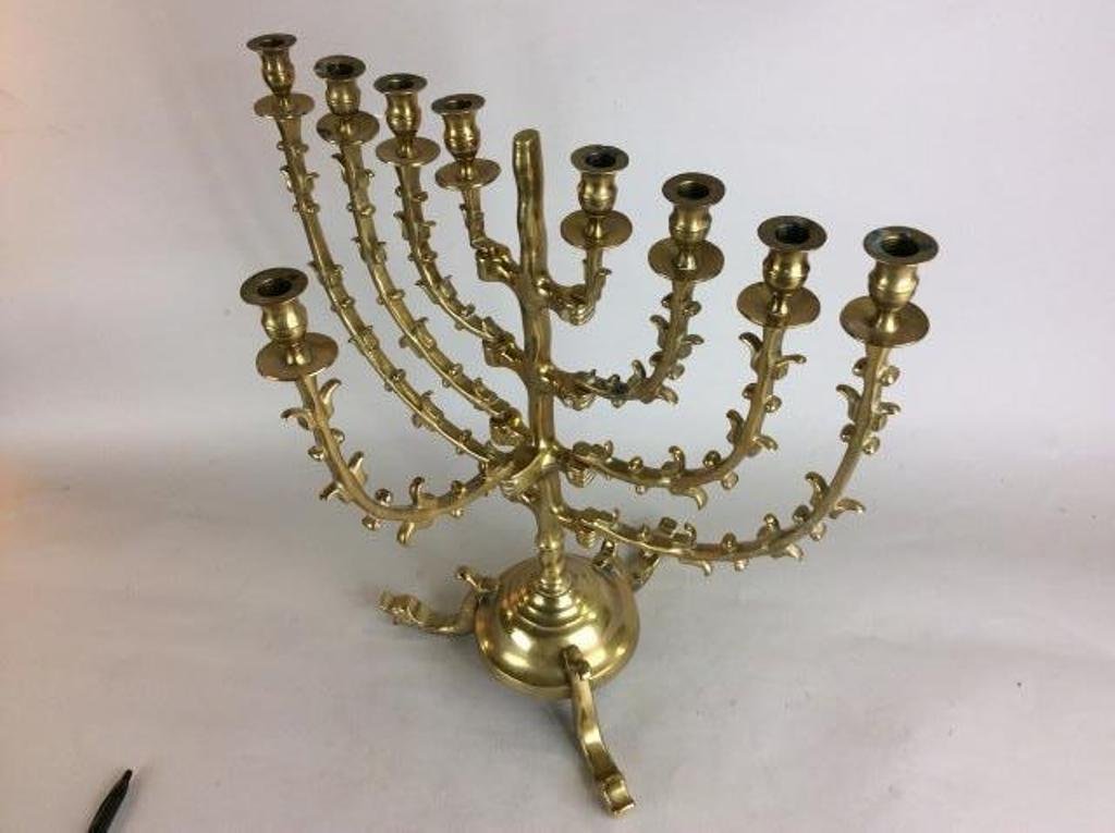 BRONZE MENORAH ON DOLPHIN FEET: A hinged candle arms in a stylized foliate branch form on a base with figural fish feet. 18 1/2"H X 17"W