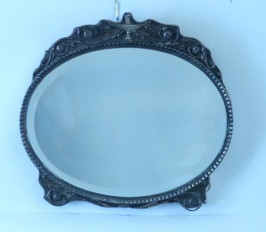 Silver Framed Dresser Mirror: 19th Century. Silver repousse on velvet covered wood backing. The federal urn form crest above an oval mirror with a leaf petal and dart boarder. 14 3/4"H X 16 3/4"W