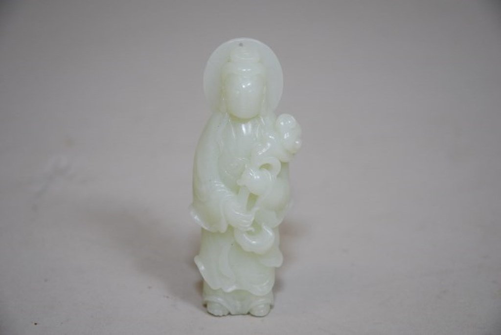 Chinese white Jade carving of a Standing Guan Yin: A Flawless translucent and perfect even-toned light celadon color of a grayish-green white Jade. Beautifully carved GuanYin Figure holding a Ruyi Scepters with Left arm above right. Serene Face with l
