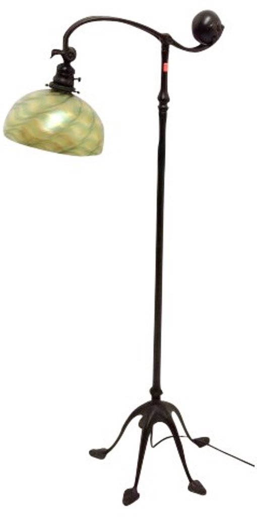 Tiffany Studios Floor Lamp: An antique Tiffany Studios dark patinated bronze counter balance floor lamp topped by an adjustable arm with ball in a leaf shaped cradle and with a hemispherical shade of wavy yellow, orange and gree