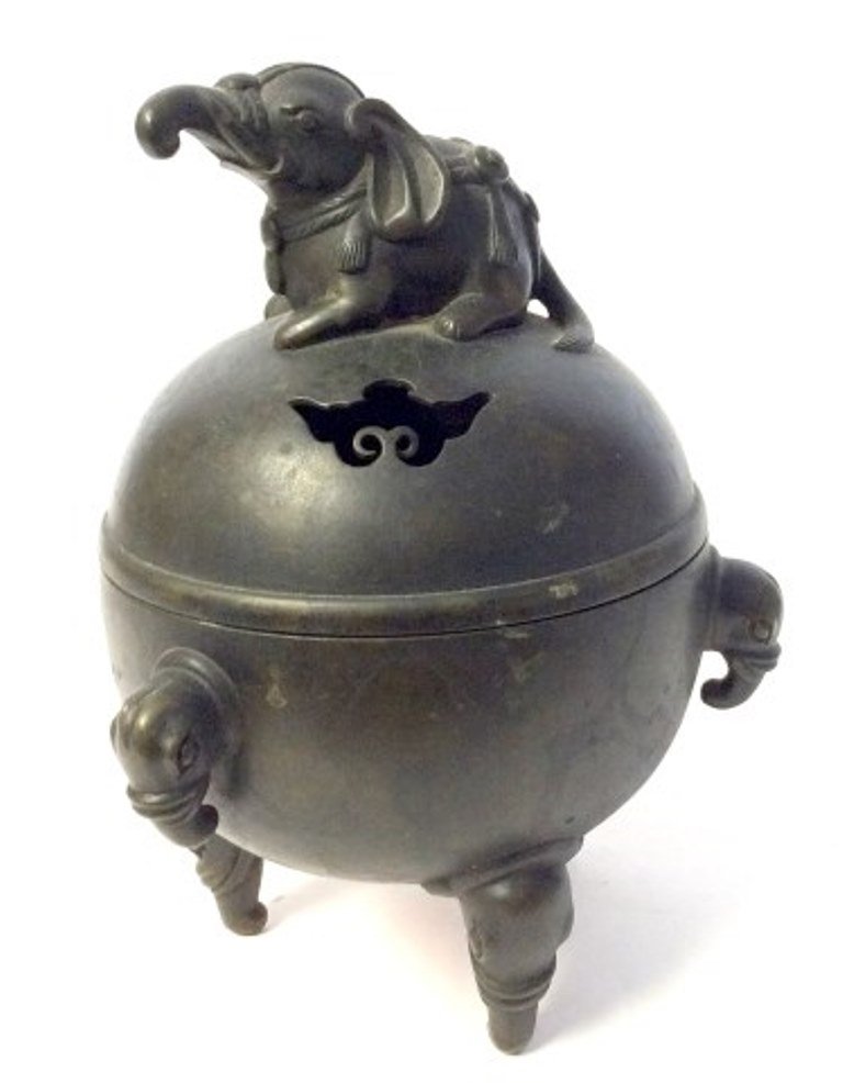 Chinese Incense Bowl: An antique Chinese dark patinated bronze pierced spherical lidded and footed incense bowl. The lid mounted with a full figural elephant finial. The body having triple elephant head handles and resting