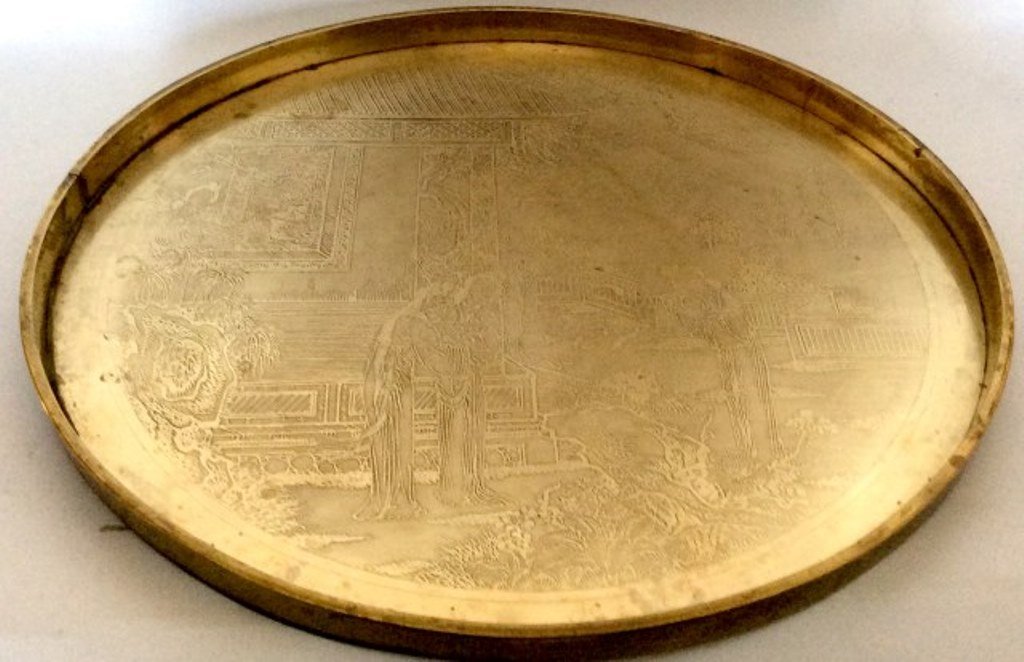Chinese Bronze Tray: An antique Chinese bronze circular galleried tray having all over engraved decoration depicting a woman in a palace garden with female attendants. Bears raised character marks middle right. Measures: 