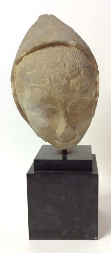 Medieval Burgundian Fragment: A Medieval early Burgundian carved limestone head fragment of a figure wearing a three quarter pointed cap revealing scored combed locks of hair. Possibly 13th Century. Mounted on a black onyx square