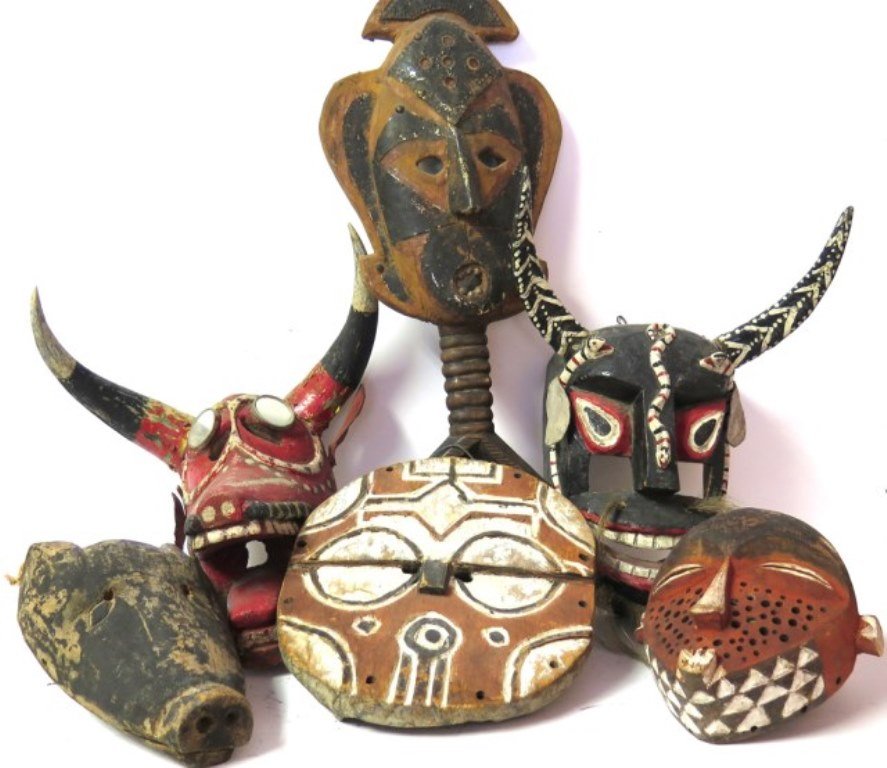Tribal African Masks Group Six: A group of six various carved and polychrome wooden African ceremonial masks. Along with a raffia coil monkey mask mounted in a shadow box frame. The largest measures: 9½" L X 4" W X 25" H