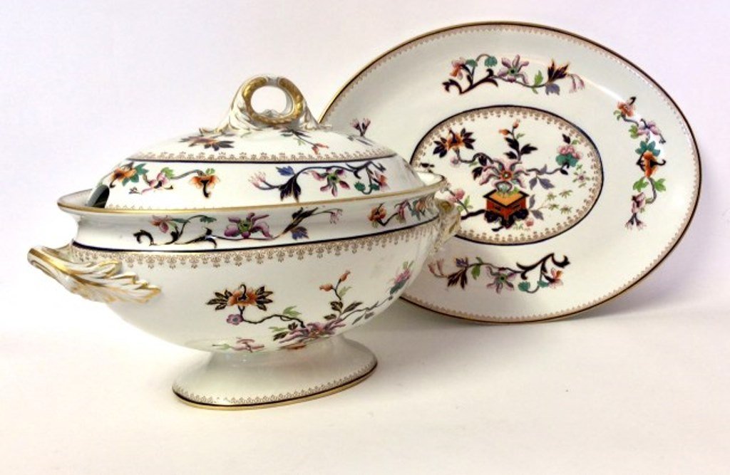 English Soup Tureen: A 19th Century English Royal Worcester polychrome porcelain lidded and oval footed soup tureen with matching underplate. Each piece decorated in an Asian Imari motif with parcel gilt decoration. Measu