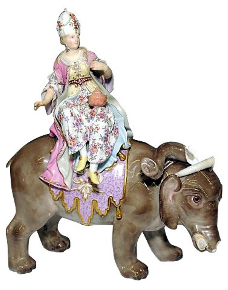 Meissen Porcelain Courtesan on Elephant: Porcelain figure of a courtesan riding an elephant. Meissen mark. 16" H X 16" L Note: With loss and repair to truck and tusk, some attached parts. missing tusk and tail 16" H X 16" L