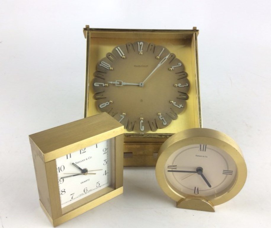 Three Dresser Clocks: Two Tiffany and Co. clocks one circular form - Swiss Quartz 3 1/2"H One square form - Quartz 31/2"H One Jager Le Coultre - lacking base 8"H; Note: Wind key lacking