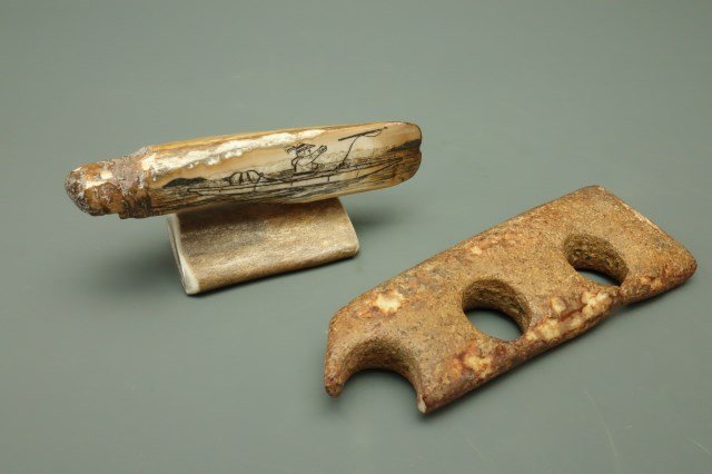 Inuit Ivory Sled Runner and signed Scrimshaw Tooth: Two Inuit items Ivory sled runner 5 1/4"L X 1 3/4"W Scrimshaw tooth or ivory depicting a fisherman in a canoe. Signed GU? 1 3/4"H X 4 1/4"W X 1 1/2"D