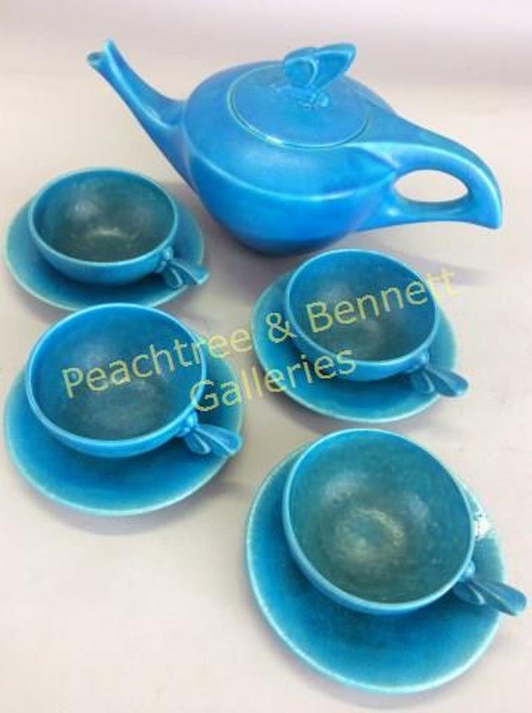 La Chanel Art Deco Tea Set: 9 pcs. Consisting of a tea pot, four matching cups and saucers. Turquoise mat underglaze. With applied butterfly handles. Artist signed. Teapot measures 6"H X 12W X 6"D