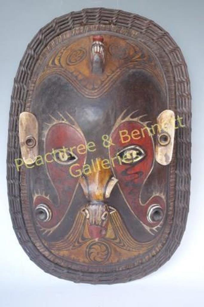 Carved Tiki Mask: Large carved and painted mask. Decorated with figural bird nose, having rattan decoration. 24.5"H X 16.5"W