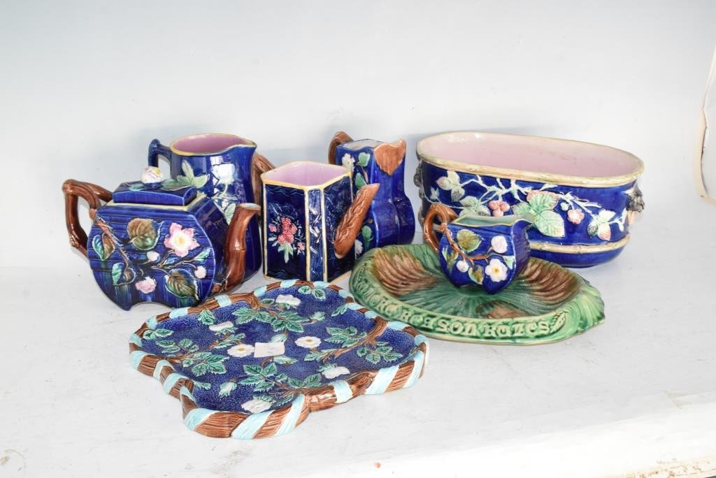 9pcs English Cobalt Blue Majolica Serveware: Includes 2 platters, 2 large pitchers, 2 cream pitchers, 2 tea pots, and a large flat bottomed serving bowl. Most cobalt blue with floral motif, one platter is a lily pad with an embossed text on the