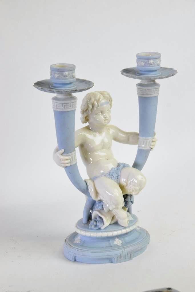 Minton Faun Candelabra: Two arm Candelabra in light blue and white with a faun seated between the two arms. Marked Minton underneath. 11 inches height, 9 inches width, 4 inches inches depth. 11"H x 9"W x 4"D 11"H x 9"W x 4"D