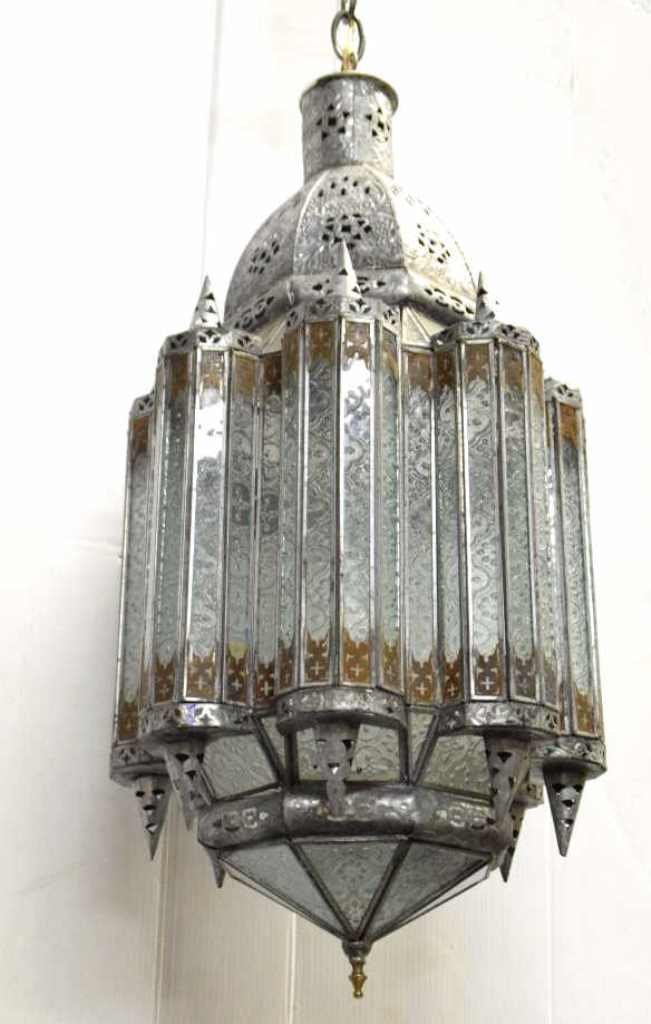Moroccan Lantern Chandelier: Moroccan metal and glass lantern re-purposed as a chandelier. Embossed metal work and molded decorative glass. 40 inches height, 8 inches diameter. 40"H x 8" Diam Good.