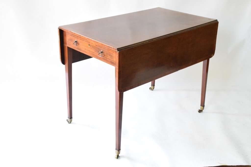 Drop Leaf Table Fitted with Single Drawer: Drop leaf table resting on tapered square legs having brass casters. 27.5 inches height, 40 1/2 inches width, 54 inches depth.
