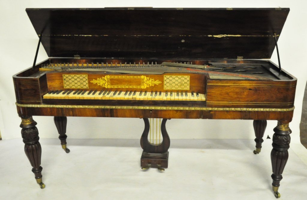 Inlaid Rosewood Piano: Rosewood piano having overall gilt double line inlay and panel above keys parcel gilt with foliage motif design. The whole raised on four turned reeded legs terminating in caster feet. 32 inches heigh