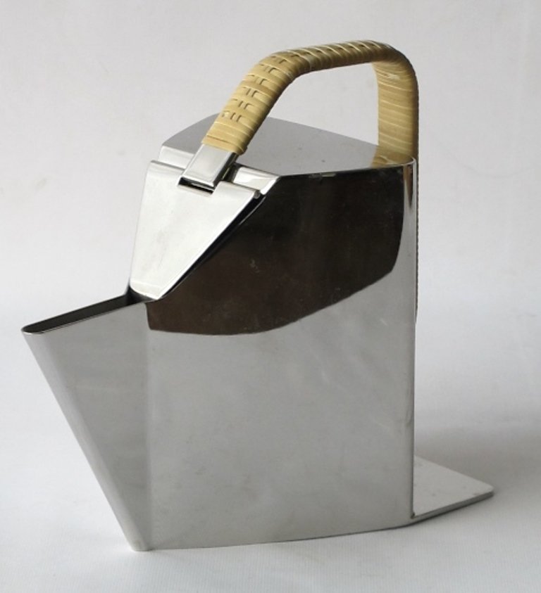 Richard Sapper (1932-) Alessi Teapot: Modern geometric form teapot deisgned by Richard Sapper for Alessi Italy. Made of stainless steel with a wicker-wrapped handle. Manufactured circa 1987 with model number 960058. 8 inches height, 5 inc