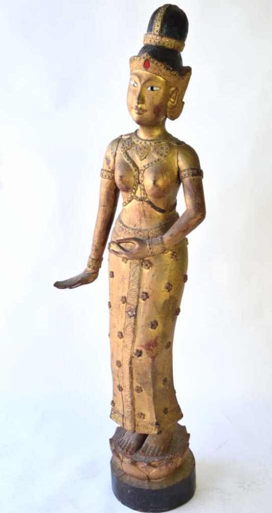 Large Asian Carved Wood Figure of a Woman: Asian Hundu or Buddhist figure of a woman having gilt and inset glass. Depicted in a floral dress with foliate pattern trim, bare chested with jeweled top and headdress. 61 inches height, 19 inches wi