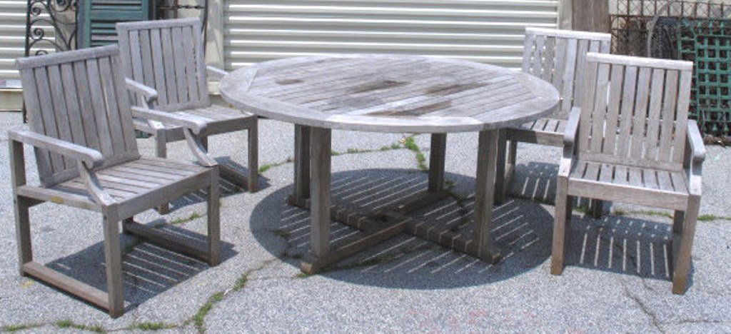 Wooden Patio Table and Chairs: Wooden round patio table having circular surface form and geometric support pedestal. Including four simple armchairs in same material. 28.5 inches height, 60 inches width, 60 inches depth for table.