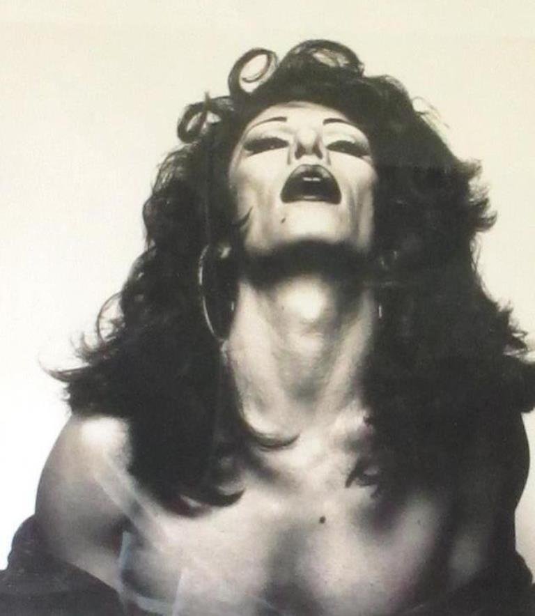 Michel Comte Drag Queen Print: Print of black and white photograph by Michel Comte. Depicting a man wearing a full face of makeup and wig. Housed in a black wood frame. 25 inches height, 21 inches width, 1 inch depth. Visual image