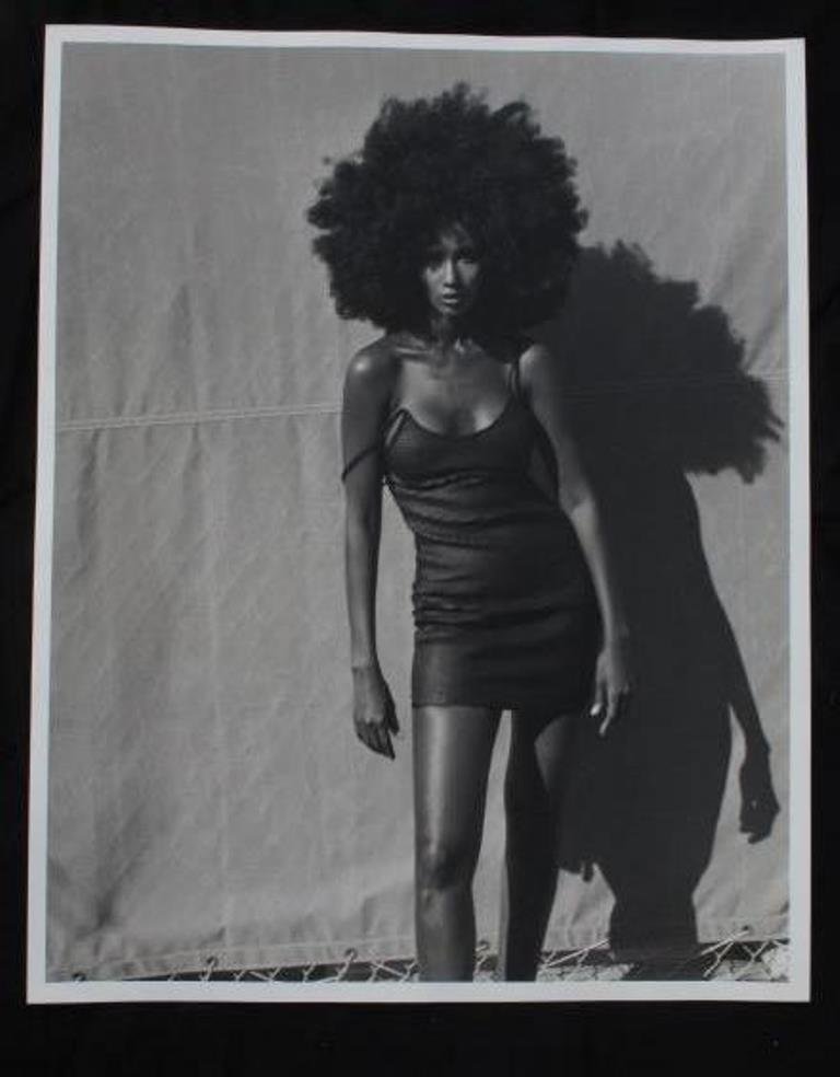 Michel Comte (1954-) Portrait of Iman: Black and white photographic print on baryta paper by acclaimed fashion photographer Michel Comte. Depicting Somali supermodel Iman in a black mini dress with natural afro hairstyle. Artist's mark in