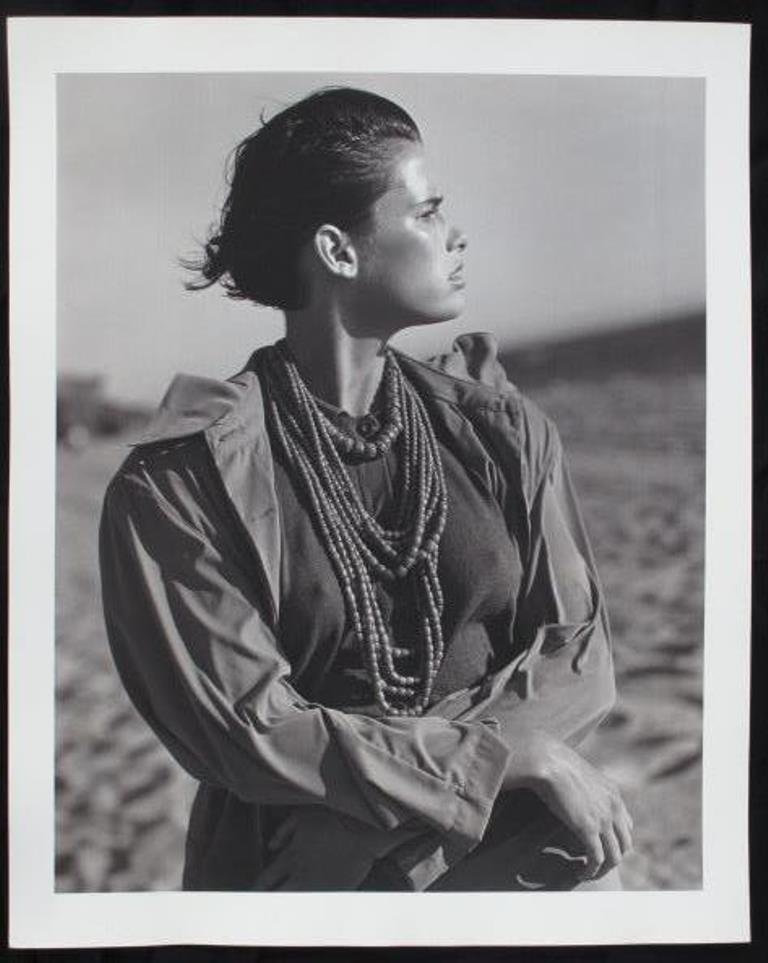 Michel Comte (1954-) Fashion Print: Black and white photographic print on baryta paper by Michel Comte. Depicting a female model in a sandy landscape looking to the right and wearing beaded necklaces. Artist's marks in pencil and stamp