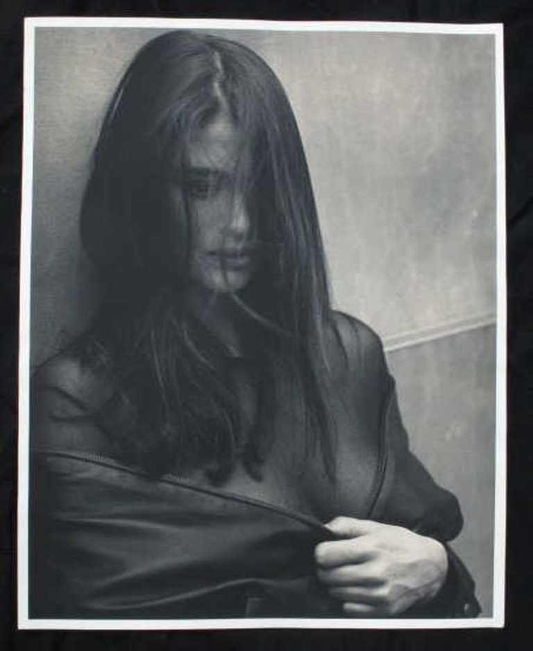 Michel Comte (1954-) Baryta Print: Black and white photographic print on baryta paper by Swiss photographer Michel Comte. Depicting a woman in black jacket with hair covering her face. Artist's marks in pencil to verso. 20 inches heigh