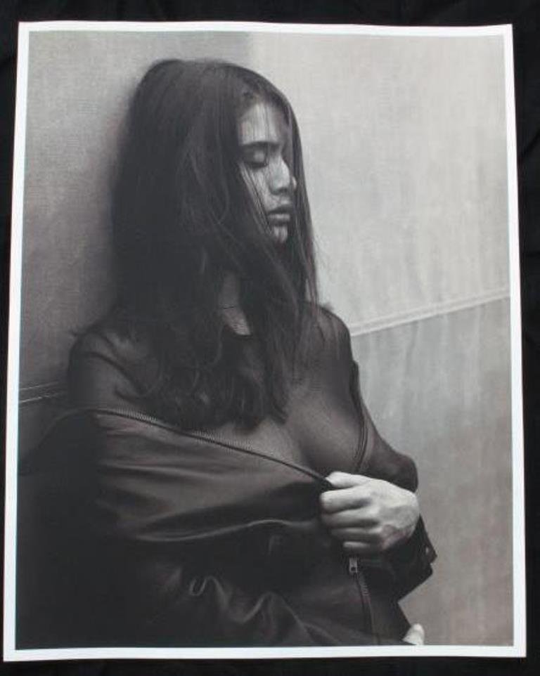 Michel Comte (1954-) Photographic Print: Photographic print in black and white on baryta paper by acclaimed Swiss photographer Michel Comte. Depicting a woman holding together a zippered garment with her hair covering her face. Artist's mark