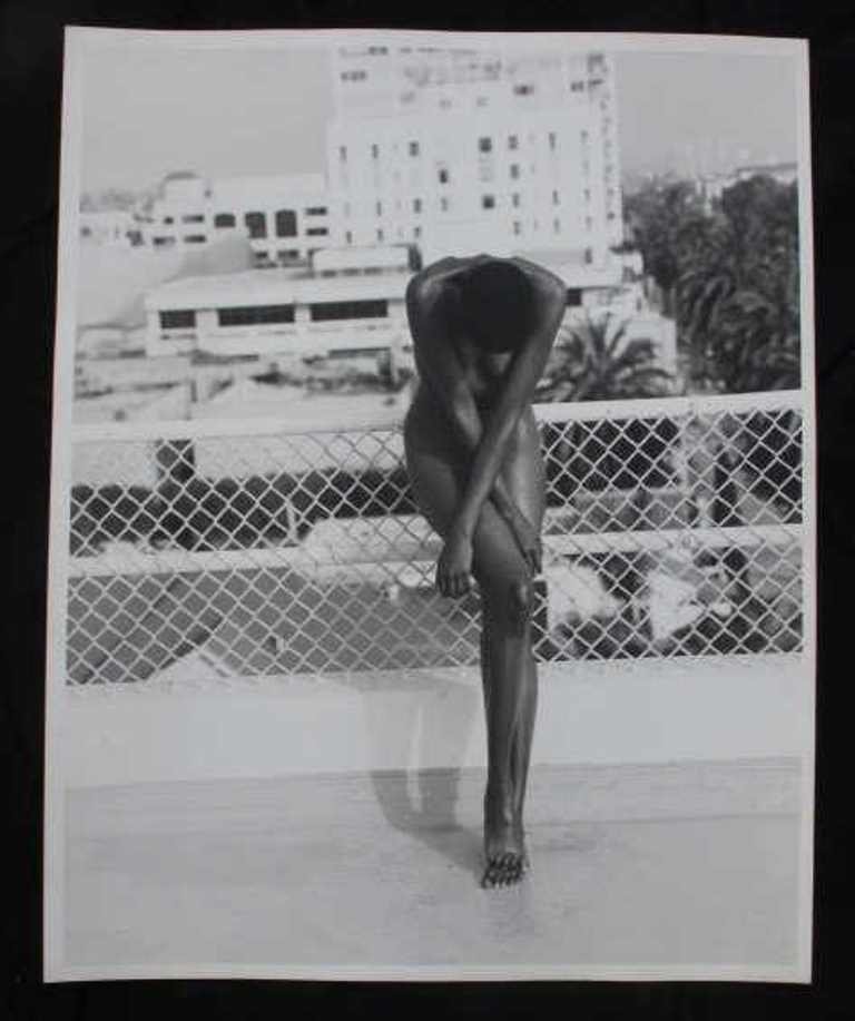 Baryta Print by Michel Comte (1954-): Photographic black and white print on baryta paper by acclaimed fashion photographer Michel Comte. Depicting a nude woman with arms crossed over her body standing in front of a cityscape. Artist's mar